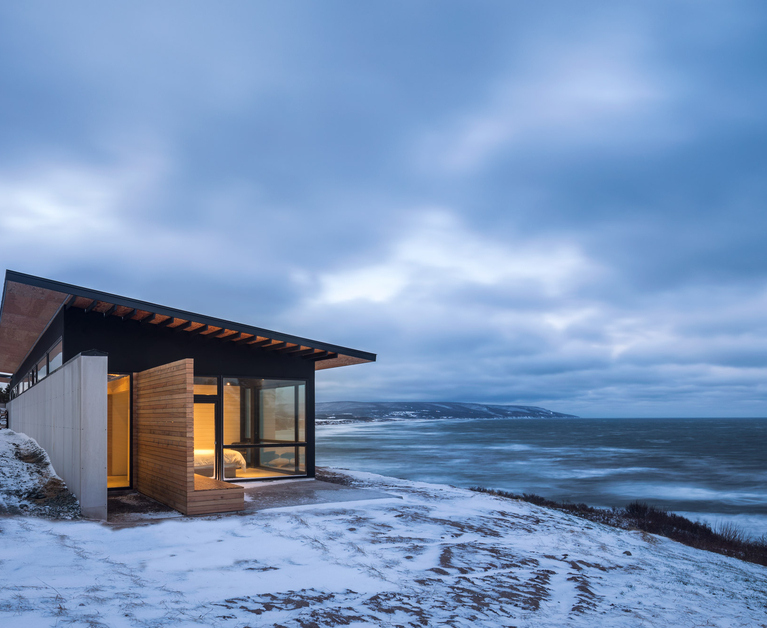 Glass-walled cabin on rocky cliff with amazing view